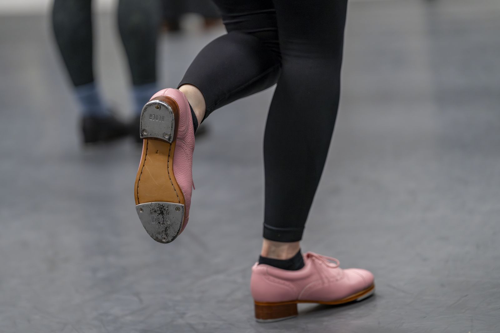 Tap shoes mid-step on the studio floor